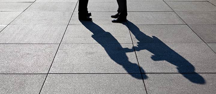 feet and shadow of people shaking hands